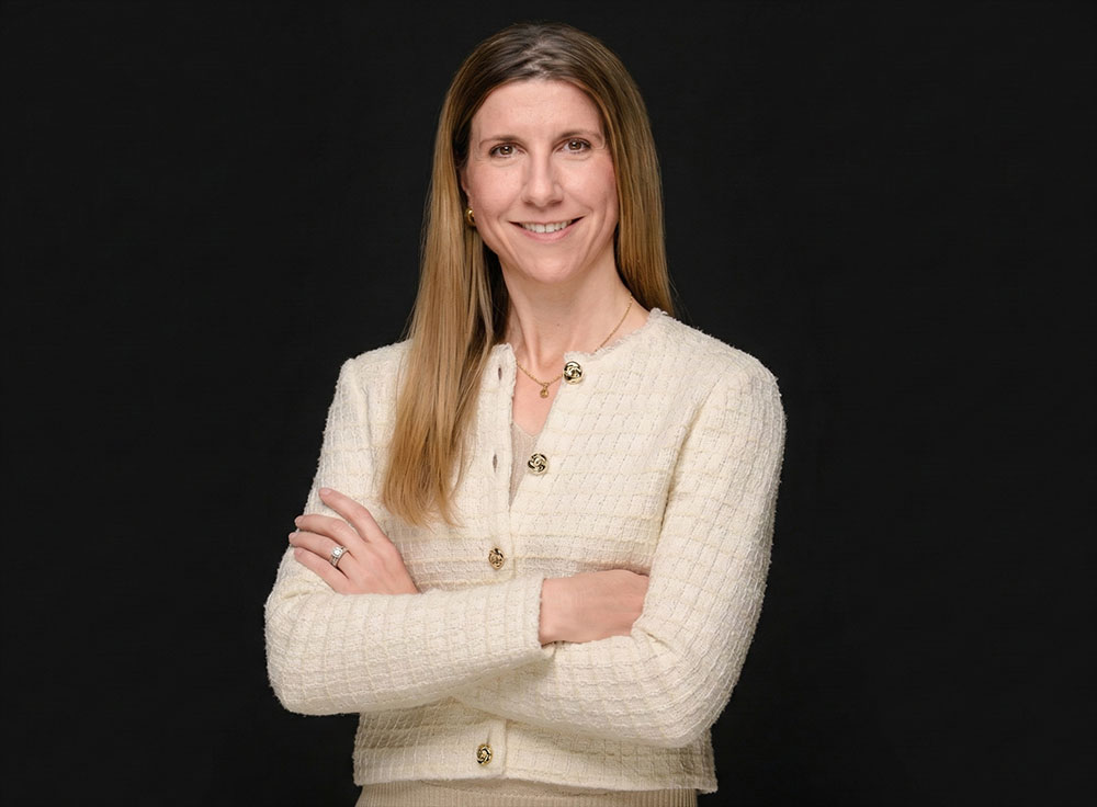 Frau mit verschränkten Armen vor schwarzem Hintergrund