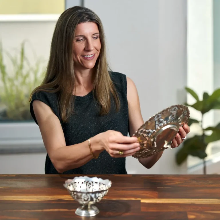 Frau betrachtet verzierte silberne Schale